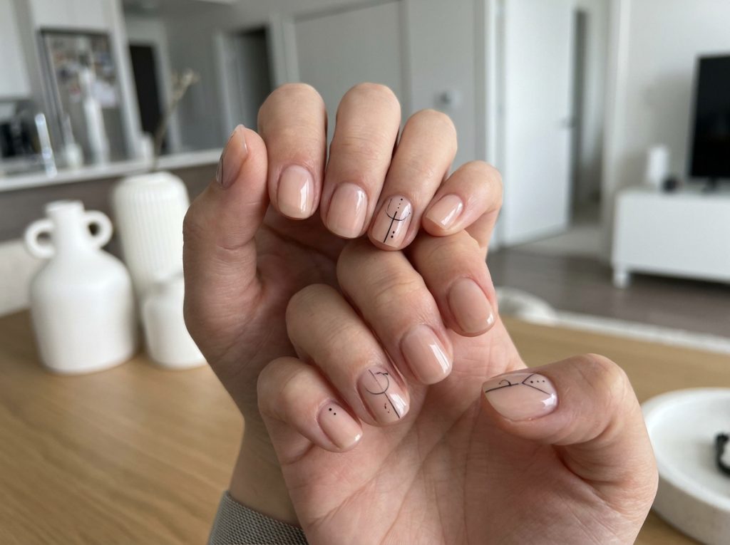 “short nude nails with minimal black line art, clean aesthetic, modern style”