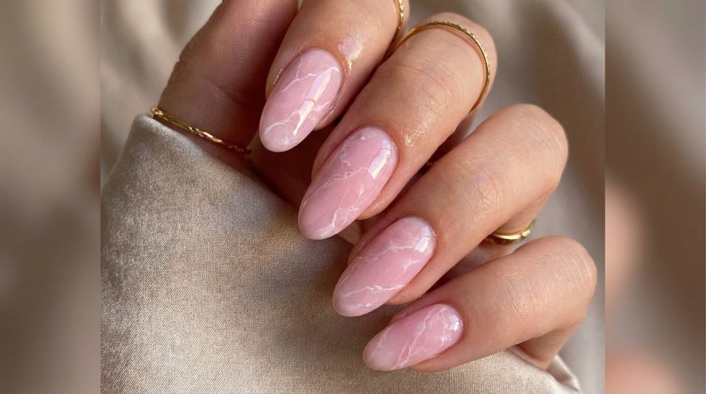 "Pastel pink marble nails, white veining pattern, glossy finish, long oval shape, luxury editorial aesthetic, soft lighting photography, Pinterest nail inspo 2026"